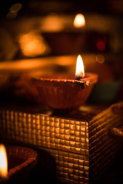 Diwali diya veya hediyeler, moody arka plan üzerinde çiçekler ile gece aydınlatma. Seçici odak