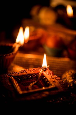 Diwali diya veya hediyeler, moody arka plan üzerinde çiçekler ile gece aydınlatma. Seçici odak