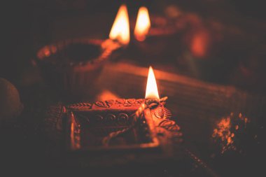Diwali diya veya hediyeler, moody arka plan üzerinde çiçekler ile gece aydınlatma. Seçici odak