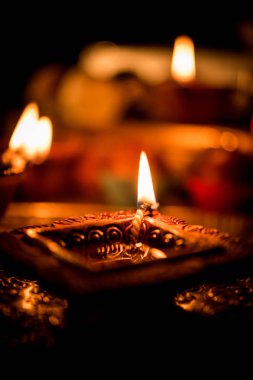 Diwali diya veya hediyeler, moody arka plan üzerinde çiçekler ile gece aydınlatma. Seçici odak
