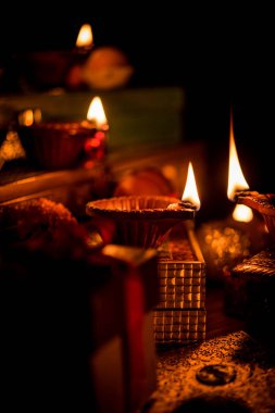 Diwali diya veya hediyeler, moody arka plan üzerinde çiçekler ile gece aydınlatma. Seçici odak