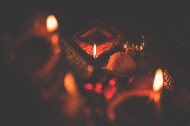 Diwali diya veya hediyeler, moody arka plan üzerinde çiçekler ile gece aydınlatma. Seçici odak