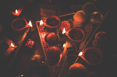Diwali diya veya hediyeler, moody arka plan üzerinde çiçekler ile gece aydınlatma. Seçici odak