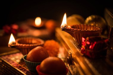Diwali diya veya hediyeler, moody arka plan üzerinde çiçekler ile gece aydınlatma. Seçici odak