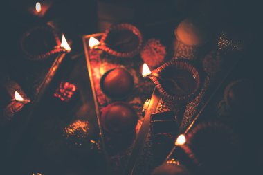 Diwali diya veya hediyeler, moody arka plan üzerinde çiçekler ile gece aydınlatma. Seçici odak