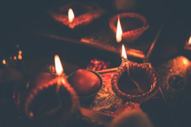 Diwali diya veya hediyeler, moody arka plan üzerinde çiçekler ile gece aydınlatma. Seçici odak