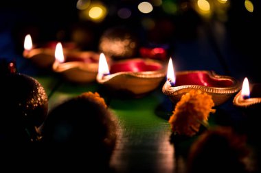 Diwali diya veya hediyeler, moody arka plan üzerinde çiçekler ile gece aydınlatma. Seçici odak