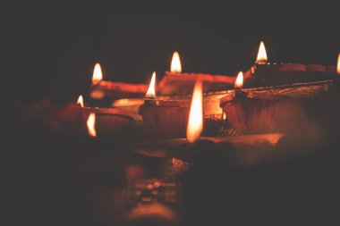 Diwali diya veya hediyeler, moody arka plan üzerinde çiçekler ile gece aydınlatma. Seçici odak