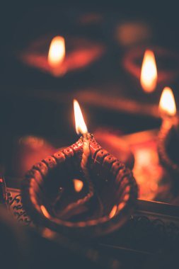 Diwali diya veya hediyeler, moody arka plan üzerinde çiçekler ile gece aydınlatma. Seçici odak