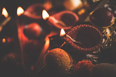 Diwali diya veya hediyeler, moody arka plan üzerinde çiçekler ile gece aydınlatma. Seçici odak