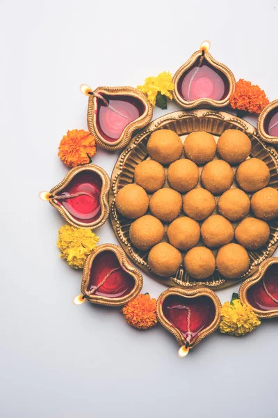 Diwali Rangoli Diya, çiçek ve Besan Laddu veya Laddoo arrabged beyaz arka plan üzerinde seçici odak kullanarak