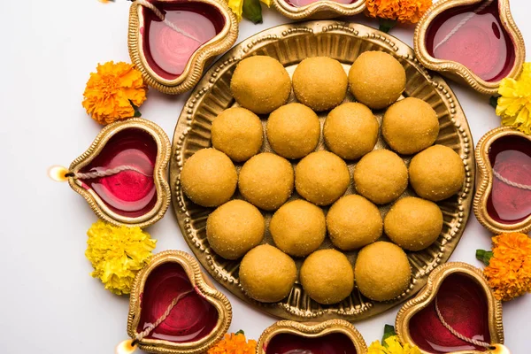 Diwali Rangoli Diya, çiçek ve Besan Laddu veya Laddoo arrabged beyaz arka plan üzerinde seçici odak kullanarak