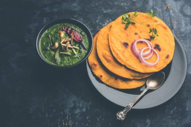 Makki di roti with sarson ka saag, popular punjabi main course recipe in winters made using corn breads mustard leaves curry. served over moody background. selective focus clipart