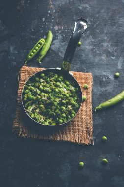 Yeşil bezelye bir hizmet tava ya da pişmiş toprak kapta hizmet tarifi veya matar kı sookhi sabji kuru. Seçici odak