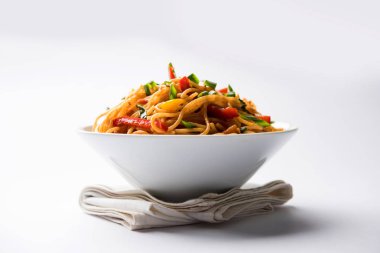Schezwan erişte veya sebze Hakka erişte veya chow mein tahta çubukla bir kase veya plaka servis popüler Hint-Çin yemek tarifleri, var. seçici odak