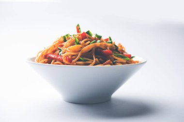 Schezwan erişte veya sebze Hakka erişte veya chow mein tahta çubukla bir kase veya plaka servis popüler Hint-Çin yemek tarifleri, var. seçici odak