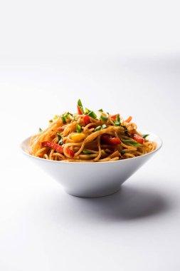 Schezwan erişte veya sebze Hakka erişte veya chow mein tahta çubukla bir kase veya plaka servis popüler Hint-Çin yemek tarifleri, var. seçici odak
