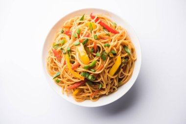 Schezwan erişte veya sebze Hakka erişte veya chow mein tahta çubukla bir kase veya plaka servis popüler Hint-Çin yemek tarifleri, var. seçici odak