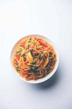 Schezwan erişte veya sebze Hakka erişte veya chow mein tahta çubukla bir kase veya plaka servis popüler Hint-Çin yemek tarifleri, var. seçici odak