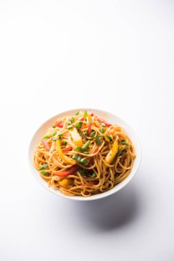 Schezwan erişte veya sebze Hakka erişte veya chow mein tahta çubukla bir kase veya plaka servis popüler Hint-Çin yemek tarifleri, var. seçici odak