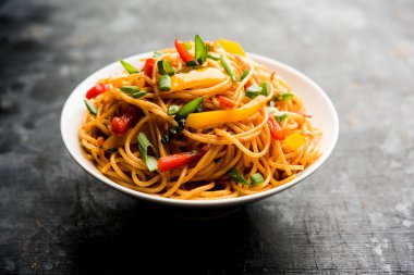 Schezwan erişte veya sebze Hakka erişte veya chow mein tahta çubukla bir kase veya plaka servis popüler Hint-Çin yemek tarifleri, var. seçici odak