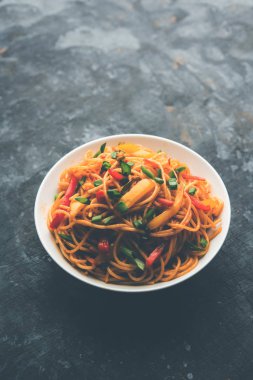 Schezwan erişte veya sebze Hakka erişte veya chow mein tahta çubukla bir kase veya plaka servis popüler Hint-Çin yemek tarifleri, var. seçici odak