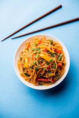 Schezwan erişte veya sebze Hakka erişte veya chow mein tahta çubukla bir kase veya plaka servis popüler Hint-Çin yemek tarifleri, var. seçici odak