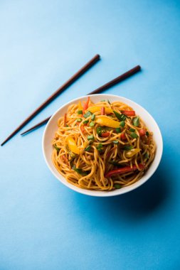 Schezwan erişte veya sebze Hakka erişte veya chow mein tahta çubukla bir kase veya plaka servis popüler Hint-Çin yemek tarifleri, var. seçici odak