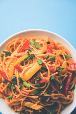 Schezwan erişte veya sebze Hakka erişte veya chow mein tahta çubukla bir kase veya plaka servis popüler Hint-Çin yemek tarifleri, var. seçici odak