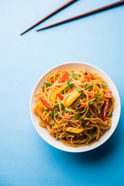 Schezwan erişte veya sebze Hakka erişte veya chow mein tahta çubukla bir kase veya plaka servis popüler Hint-Çin yemek tarifleri, var. seçici odak