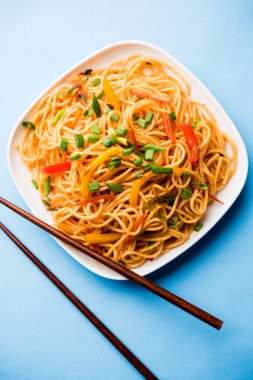 Schezwan erişte veya sebze Hakka erişte veya chow mein tahta çubukla bir kase veya plaka servis popüler Hint-Çin yemek tarifleri, var. seçici odak