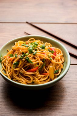 Schezwan erişte veya sebze Hakka erişte veya chow mein tahta çubukla bir kase veya plaka servis popüler Hint-Çin yemek tarifleri, var. seçici odak