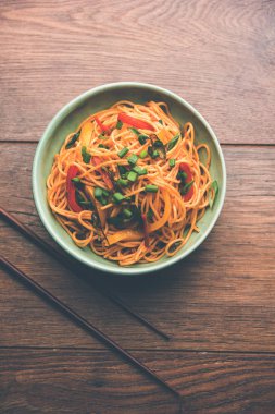 Schezwan erişte veya sebze Hakka erişte veya chow mein tahta çubukla bir kase veya plaka servis popüler Hint-Çin yemek tarifleri, var. seçici odak