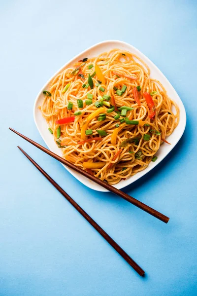 Schezwan erişte veya sebze Hakka erişte veya chow mein tahta çubukla bir kase veya plaka servis popüler Hint-Çin yemek tarifleri, var. seçici odak