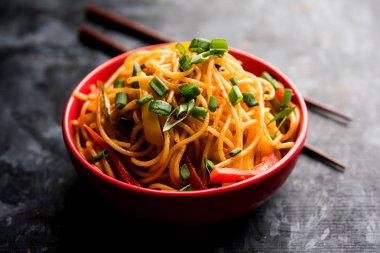 Schezwan erişte veya sebze Hakka erişte veya chow mein tahta çubukla bir kase veya plaka servis popüler Hint-Çin yemek tarifleri, var. seçici odak