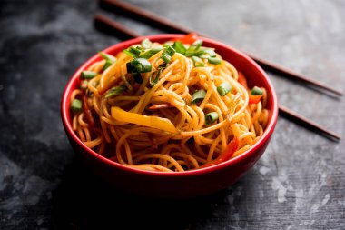 Schezwan erişte veya sebze Hakka erişte veya chow mein tahta çubukla bir kase veya plaka servis popüler Hint-Çin yemek tarifleri, var. seçici odak