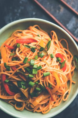 Schezwan erişte veya sebze Hakka erişte veya chow mein tahta çubukla bir kase veya plaka servis popüler Hint-Çin yemek tarifleri, var. seçici odak