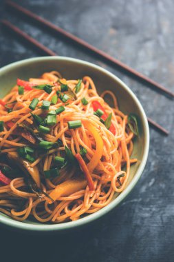 Schezwan erişte veya sebze Hakka erişte veya chow mein tahta çubukla bir kase veya plaka servis popüler Hint-Çin yemek tarifleri, var. seçici odak