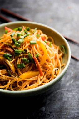 Schezwan erişte veya sebze Hakka erişte veya chow mein tahta çubukla bir kase veya plaka servis popüler Hint-Çin yemek tarifleri, var. seçici odak