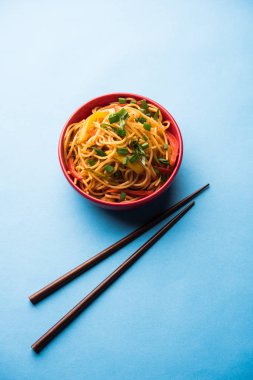 Schezwan erişte veya sebze Hakka erişte veya chow mein tahta çubukla bir kase veya plaka servis popüler Hint-Çin yemek tarifleri, var. seçici odak