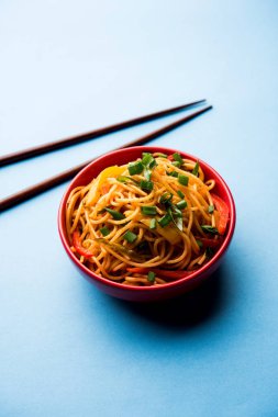 Schezwan erişte veya sebze Hakka erişte veya chow mein tahta çubukla bir kase veya plaka servis popüler Hint-Çin yemek tarifleri, var. seçici odak