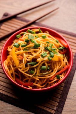 Schezwan erişte veya sebze Hakka erişte veya chow mein tahta çubukla bir kase veya plaka servis popüler Hint-Çin yemek tarifleri, var. seçici odak