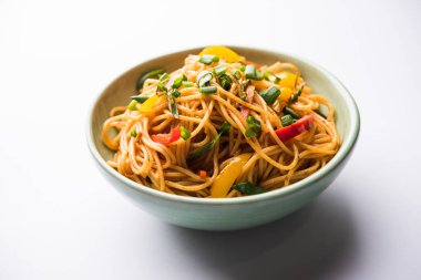 Schezwan erişte veya sebze Hakka erişte veya chow mein tahta çubukla bir kase veya plaka servis popüler Hint-Çin yemek tarifleri, var. seçici odak