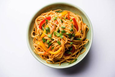 Schezwan erişte veya sebze Hakka erişte veya chow mein tahta çubukla bir kase veya plaka servis popüler Hint-Çin yemek tarifleri, var. seçici odak