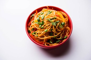 Schezwan erişte veya sebze Hakka erişte veya chow mein tahta çubukla bir kase veya plaka servis popüler Hint-Çin yemek tarifleri, var. seçici odak