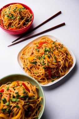 Schezwan erişte veya sebze Hakka erişte veya chow mein tahta çubukla bir kase veya plaka servis popüler Hint-Çin yemek tarifleri, var. seçici odak