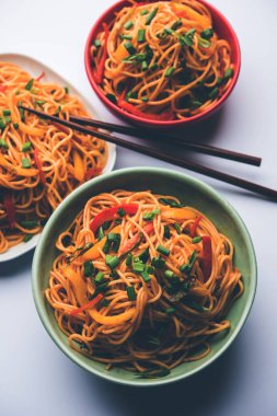 Schezwan erişte veya sebze Hakka erişte veya chow mein tahta çubukla bir kase veya plaka servis popüler Hint-Çin yemek tarifleri, var. seçici odak