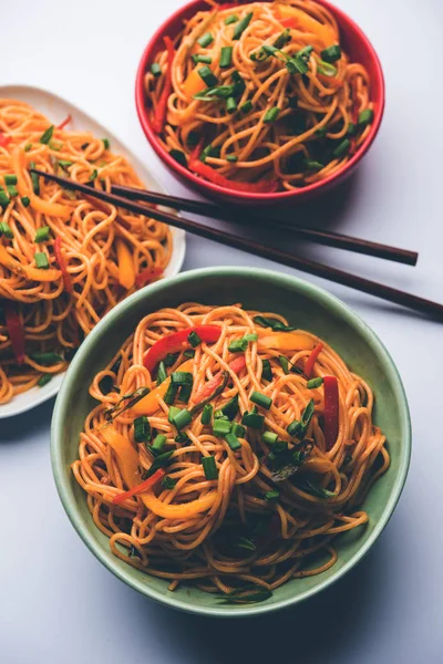 Schezwan erişte veya sebze Hakka erişte veya chow mein tahta çubukla bir kase veya plaka servis popüler Hint-Çin yemek tarifleri, var. seçici odak