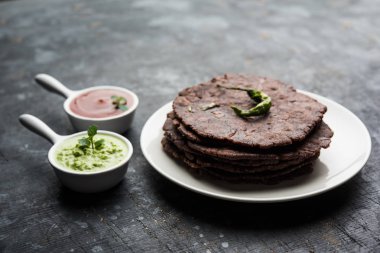 Ragi roti veya düz ekmek parmak darı kullanılarak yapılan bir sağlıklı ve lezzetli kahvaltı Karnataka, Hindistan'ın yemeğidir. yeşil biber ve Hint turşusu ile servis. seçici odak