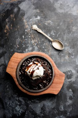 Cızırdayan çikolatalı brownie, üzerine bol bol eritilmiş çikolata dökülerek servis edilen bir top dondurmayla yapılan tatlı bir yemektir. Sunucu sıcak. seçici odak